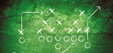 Football play diagram on a green chalkboard. White circles and X's represent players, with arrows illustrating routes and play design.