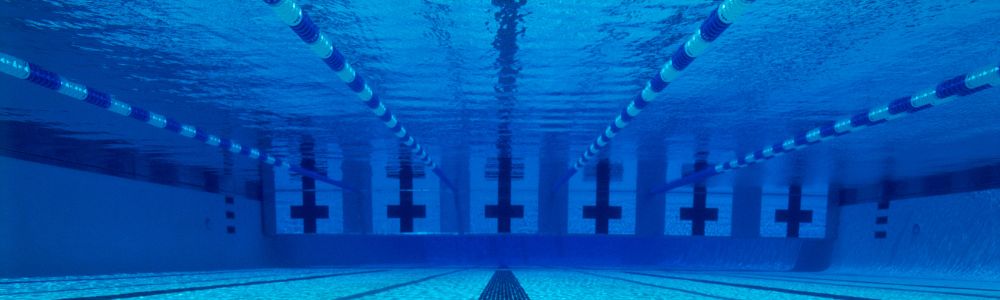 A person is swimming in a swimming pool underwater.
